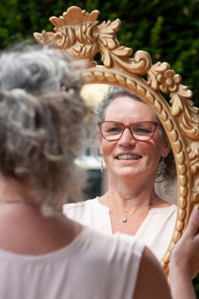 Een vrouw ziet zichzelf spiegel